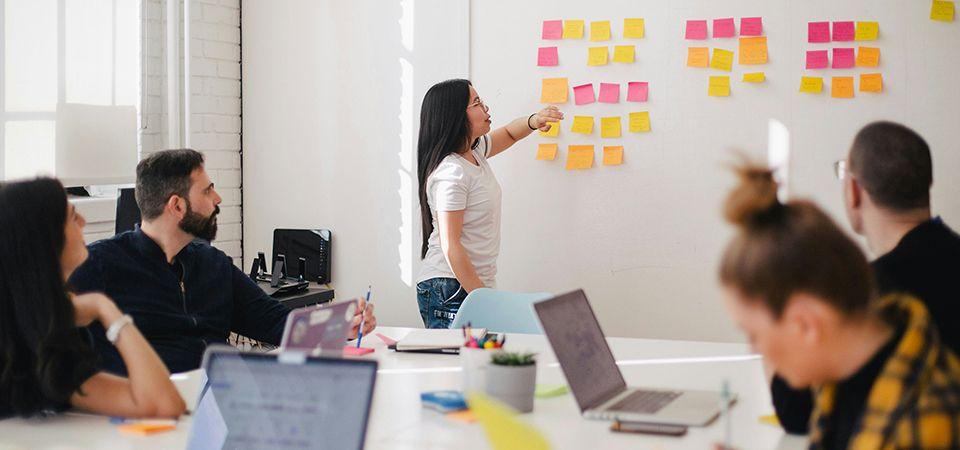 A group of professionals sits together to brainstorm at an economic development agency, mapping out strategies with sticky notes.
